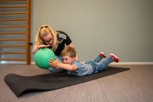 Kinderfysiotherapeut begeleidt kind bij nek en rugklachten