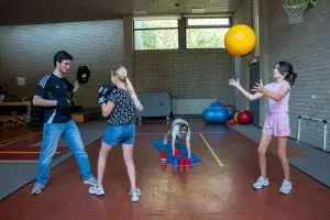 Kinderfysiotherapeut begeleidt kidsgym met jongeren